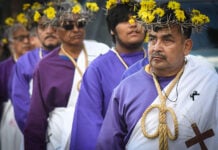 Nazarenes in purple robes and crowns of thorns and flowers walk in Mexico City