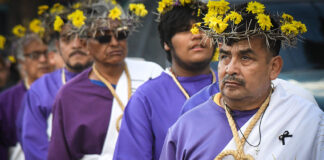 Nazarenes in purple robes and crowns of thorns and flowers walk in Mexico City