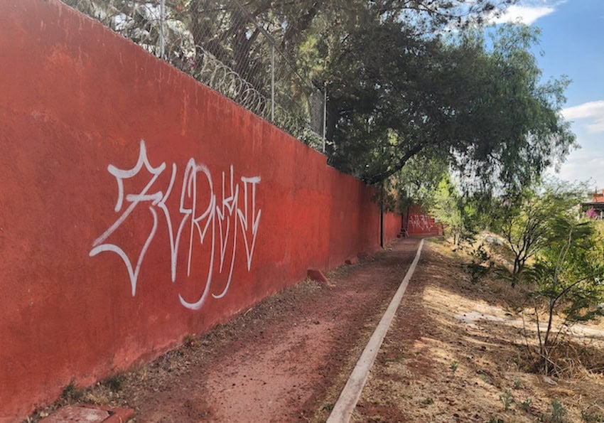 A red wall with white graffiti