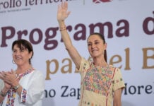 President Sheinbaum waves from the stage of a press conference