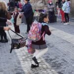 A school girl runs toward a school building