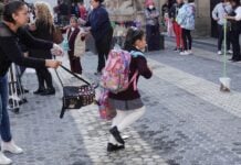 A school girl runs toward a school building