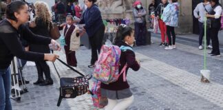 A school girl runs toward a school building