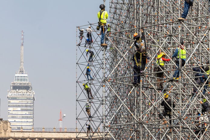Workers on scaffolding with Mexico City's Torre Latinoamericano in the background