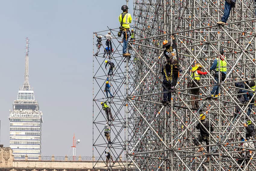 Workers on scaffolding with Mexico City's Torre Latinoamericano in the background