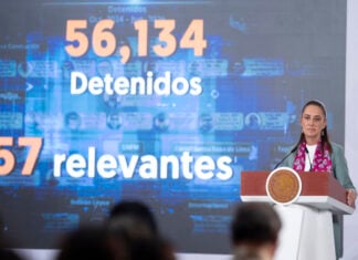 Sheinbaum stands before a graphic touting 56,134 arrests for high-impact crimes since she took office