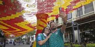 tourist take pictures with Zapopan's woven World Cup canopy