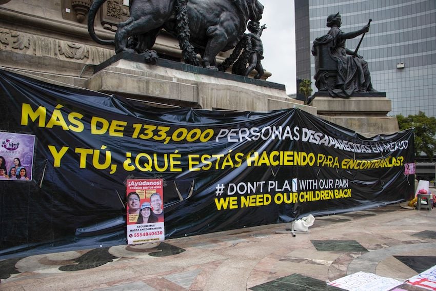 A group of protesters attached a banner to Mexico City's Angel of Independence criticizing the government's inaction regarding the more than 130,000 people registered as missing.