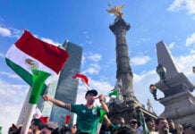 fans blow horns and wave mexican flags below the Angel of Independence monument in Mexico City after Mexico's World Cup win against south africa