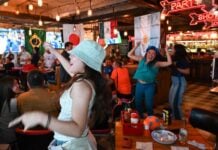 Patrons of a bar celebrate a World Cup match