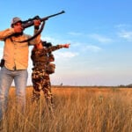 Hunters point guns in a grassy Tamaulipas plain