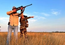 Hunters point guns in a grassy Tamaulipas plain