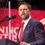 US Vice President JD Vance speaks into a microphone