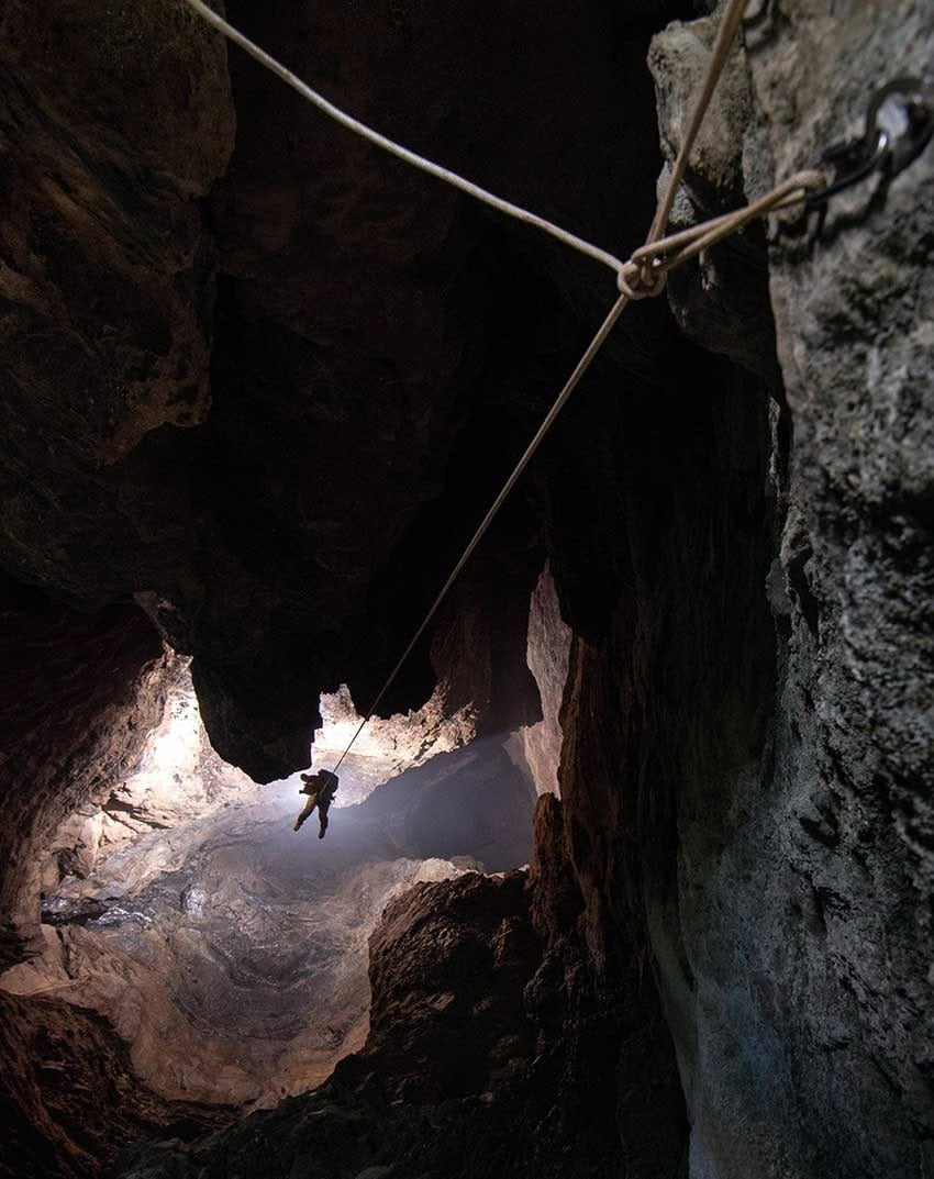 Cavers descending into a cave