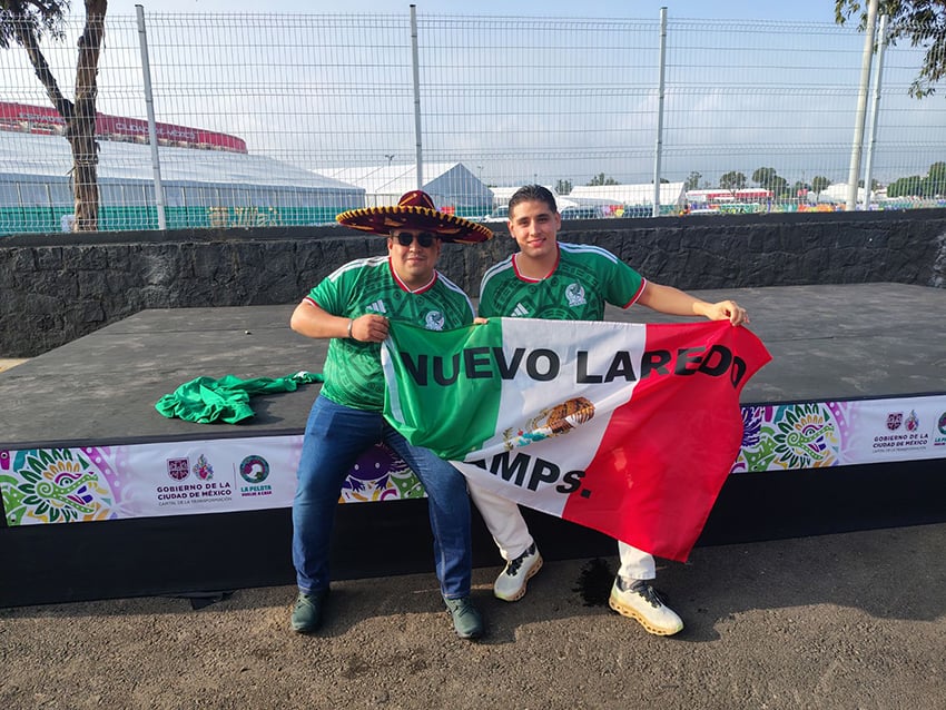 Nuevo Laredo World Cup fans hold a Mexican flag with the name of their city