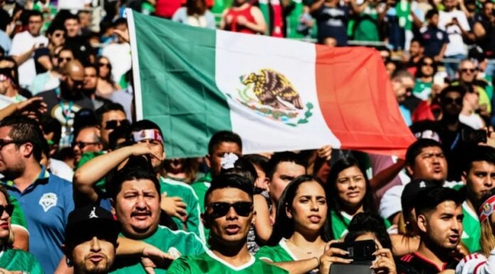 Mexicans giving the saludo civil during the national anthem at a football game