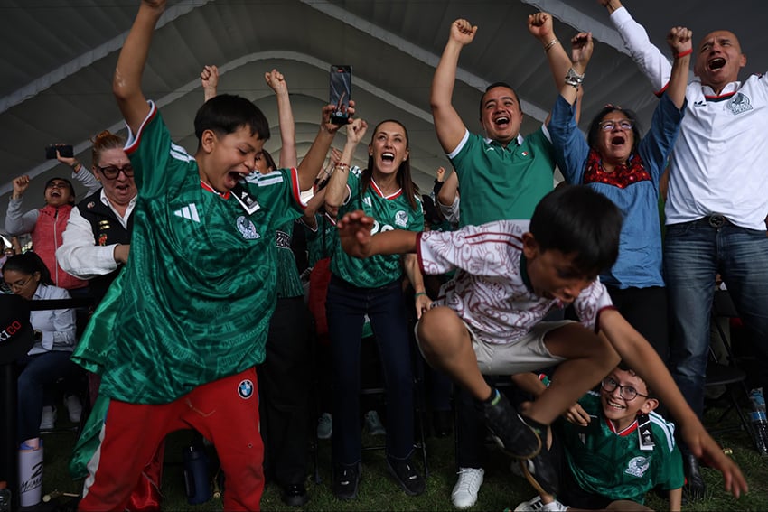 President Sheinbaum, children and families jump and cheer in excitement , wearing Mexico's World Cup jersey