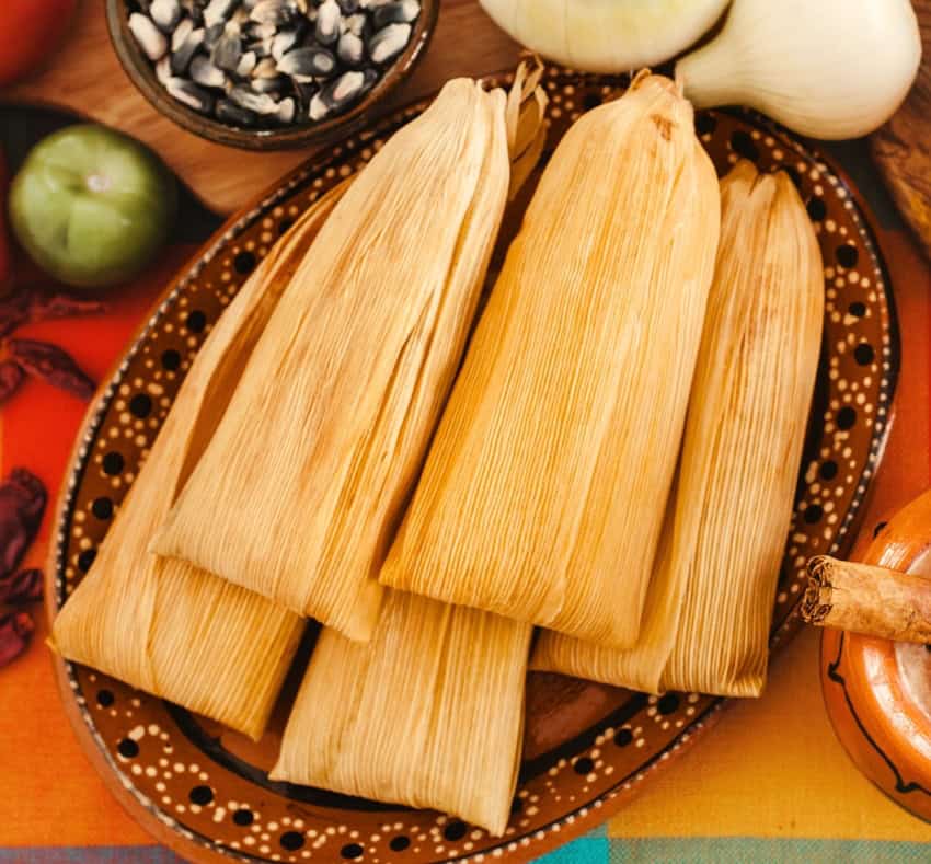 Doña Emi in Mexico City, husk-wrapped tamales on a plate