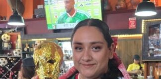 Woman holding FIFA World Cup trophy in a Puerto Vallarta restaurant