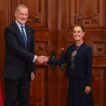 King Felipe VI of Spain's shakes hands with President Sheinbaum, posing with Spanish and Mexican flags