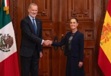 King Felipe VI of Spain's shakes hands with President Sheinbaum, posing with Spanish and Mexican flags