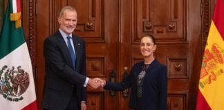 King Felipe VI of Spain's shakes hands with President Sheinbaum, posing with Spanish and Mexican flags