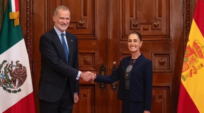 King Felipe VI of Spain's shakes hands with President Sheinbaum, posing with Spanish and Mexican flags
