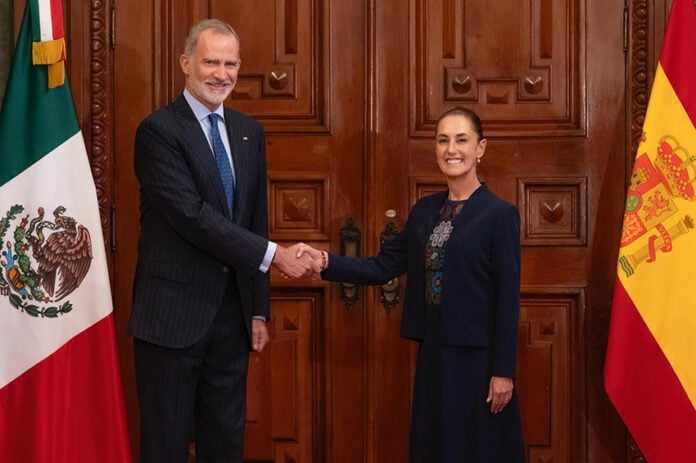 King Felipe VI of Spain's shakes hands with President Sheinbaum, posing with Spanish and Mexican flags