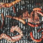 Barbecue with various meats cooking on a grill