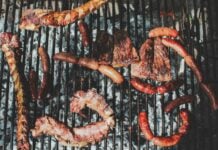 Barbecue with various meats cooking on a grill