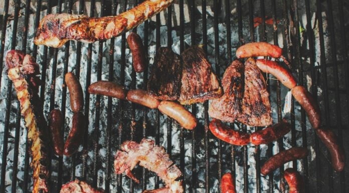 Barbecue with various meats cooking on a grill