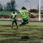 Teenagers playing football on a pitch in Oaxaca