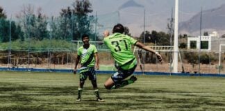 Teenagers playing football on a pitch in Oaxaca