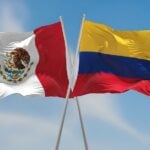 Colombian and Mexican flags waving side by side in the wind