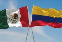 Colombian and Mexican flags waving side by side in the wind