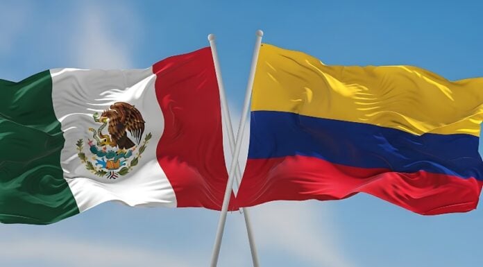 Colombian and Mexican flags waving side by side in the wind