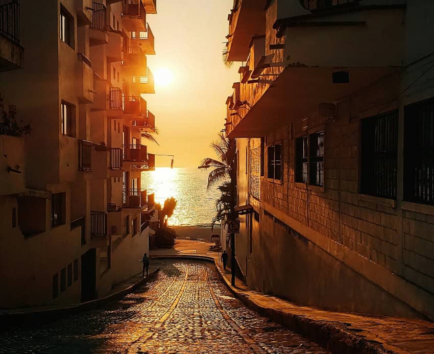Puerto Vallarta alley, empty of people, as the sun sinks beyond the Bay of Banderas