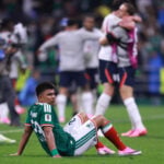 A Mexican player sits down on the field after losing in the World Cup round of 16 while England players hug in celebration