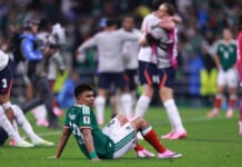 A Mexican player sits down on the field after losing in the World Cup round of 16 while England players hug in celebration