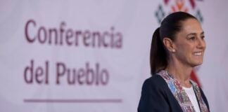 Sheinbaum stands in front of a banner reading "Conferencia del Pueblo"