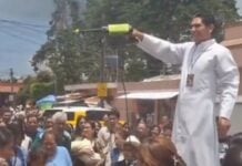 priest spraying holy water