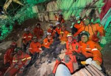 A group of Topo Azteca rescue brigade members on a pile of rubble from a collapsed building