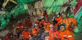 A group of Topo Azteca rescue brigade members on a pile of rubble from a collapsed building