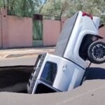 a sinkhole swallowing a pickup truck
