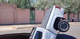 a sinkhole swallowing a pickup truck