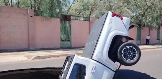 a sinkhole swallowing a pickup truck