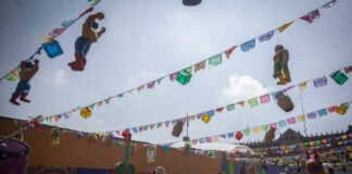 A woman walks through Mexico City's empty Zócalo, under color banners and World Cup decorations