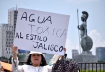 Woman holding up a sign protesting toxic Guadalajara tap water