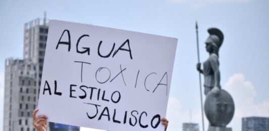 Woman holding up a sign protesting toxic Guadalajara tap water