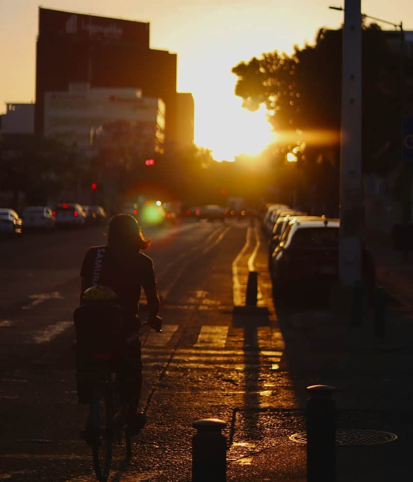 Woman on bike pedaling at sunset in Guadalajara